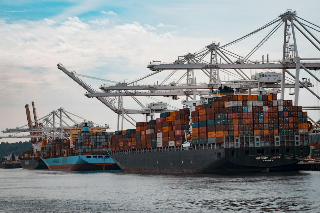 Container ship being worked by cranes at a terminal
